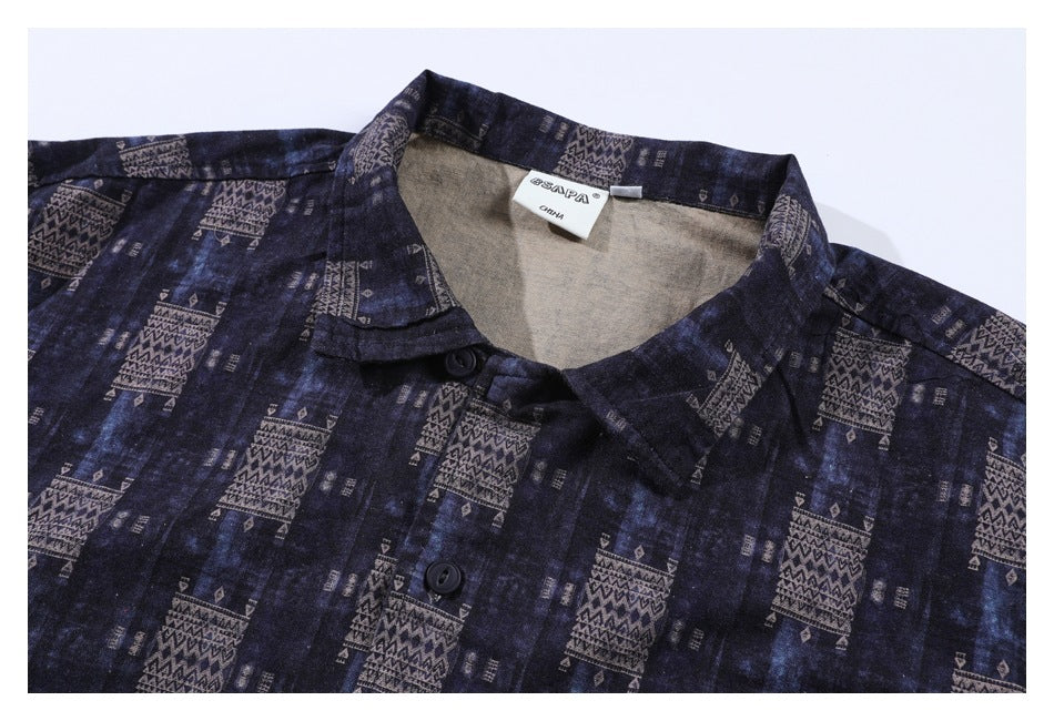 Flat lay of a dark navy button-up shirt with a collar and muted geometric print.