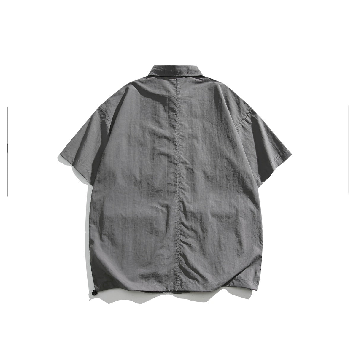 Back view of a gray oversized short-sleeve collared shirt with a center seam and adjustable hem.