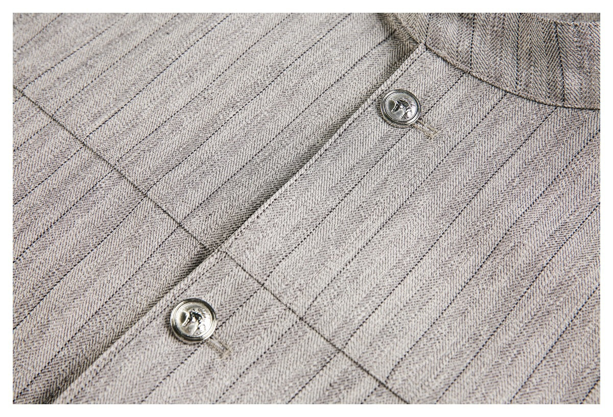 Close-up of pinstriped jacket fabric, front seam, and two silver buttons.