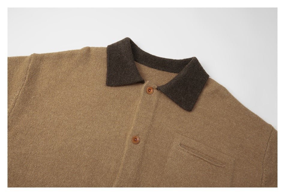 Close view of a tan knit sweater front with dark brown polo collar, buttons, and a chest pocket.