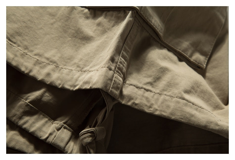 Close-up of tan trouser fabric, stitching, and a tied drawstring detail.
