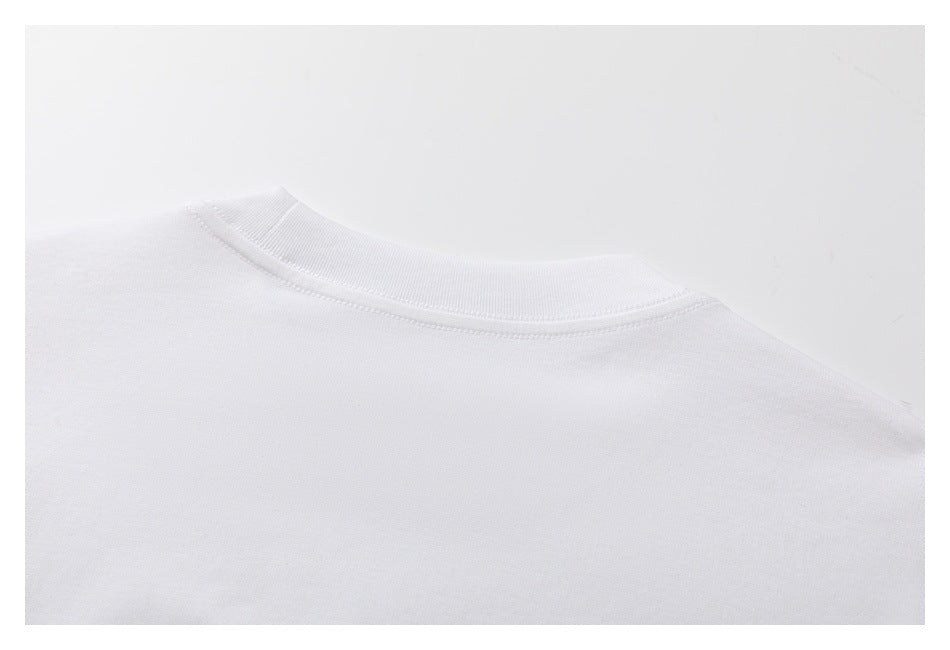 Close-up of a white garment's ribbed crew neckline and stitched collar seam.