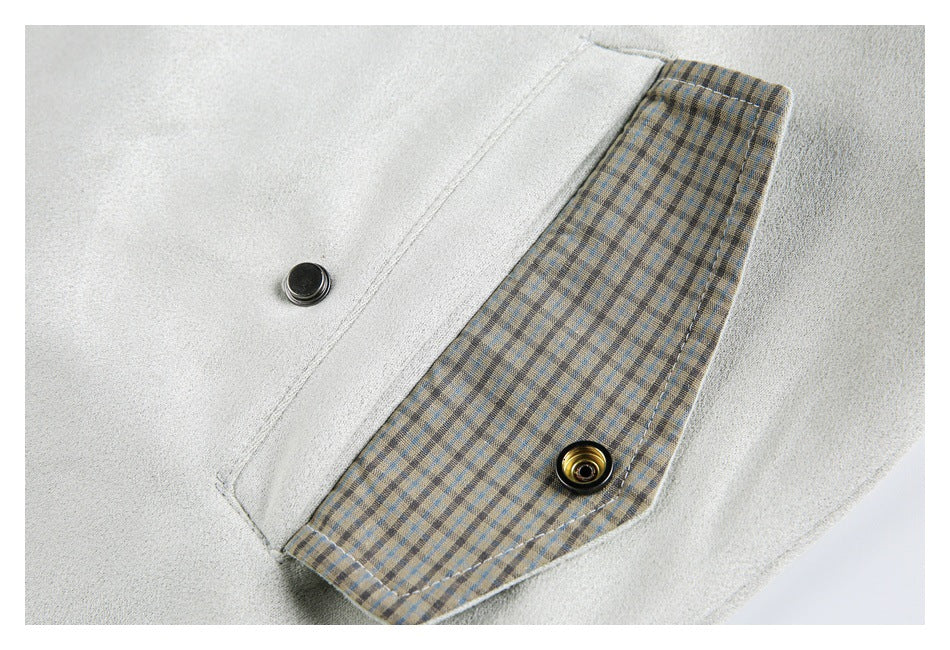 Close-up of an off-white coat cuff opened to show plaid lining and snap fasteners.