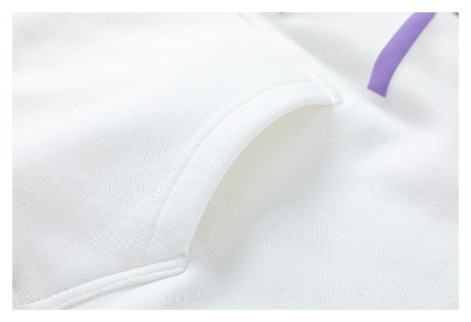 Close-up of the white hoodie's curved pocket opening and stitching.