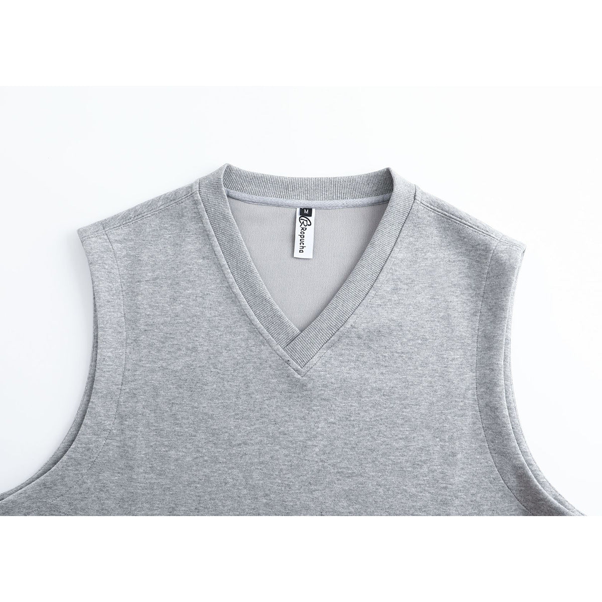 Close-up of a light gray sleeveless vest with a ribbed V-neck and a visible neck label.