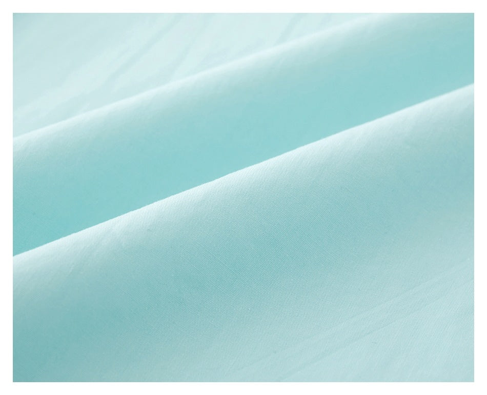 Close-up of pale aqua fabric showing smooth folds and fine surface texture.