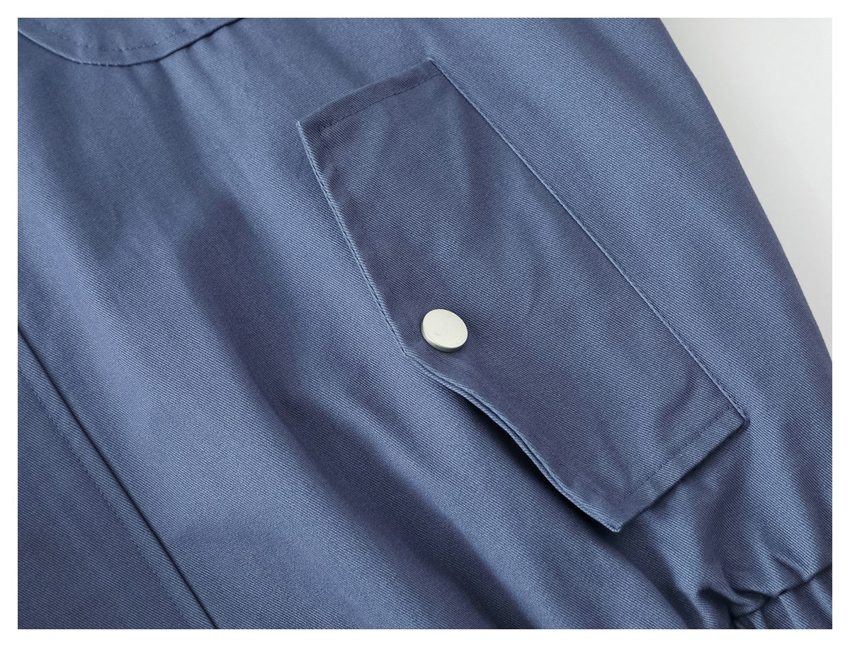 Close-up of a rectangular snap-flap pocket on the slate-blue jacket.