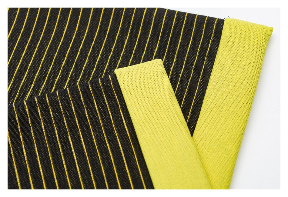 Folded black and yellow striped garment showing the bright yellow reverse side and finished edges.