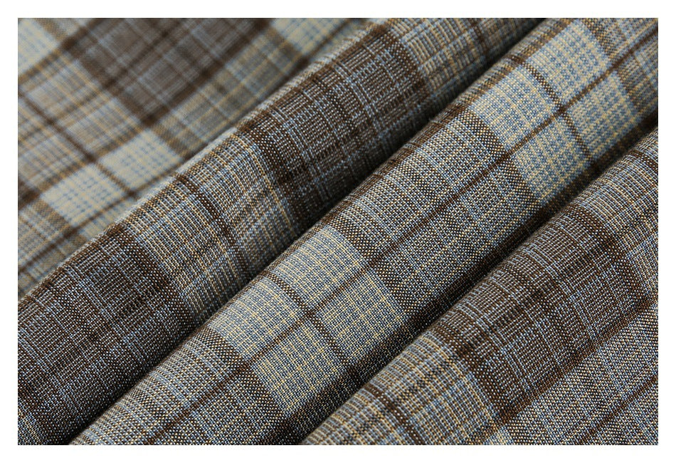 Close-up of brown, blue, and tan plaid fabric folded to show its woven texture.