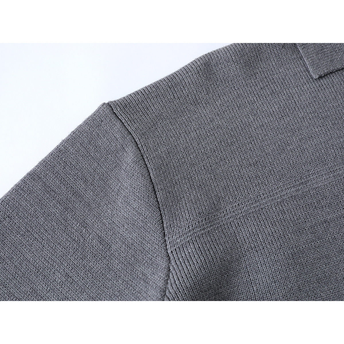 Close-up of the gray sweater's shoulder seam and textured knit.