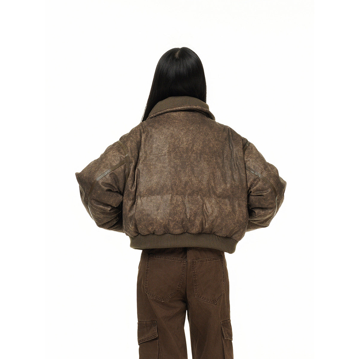 Back view of a model wearing a mottled brown cropped jacket with a ribbed hem and dark brown cargo pants.