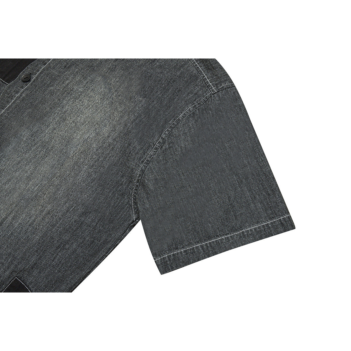 Close-up of a short sleeve on a charcoal gray shirt, showing curved seams and white contrast stitching.