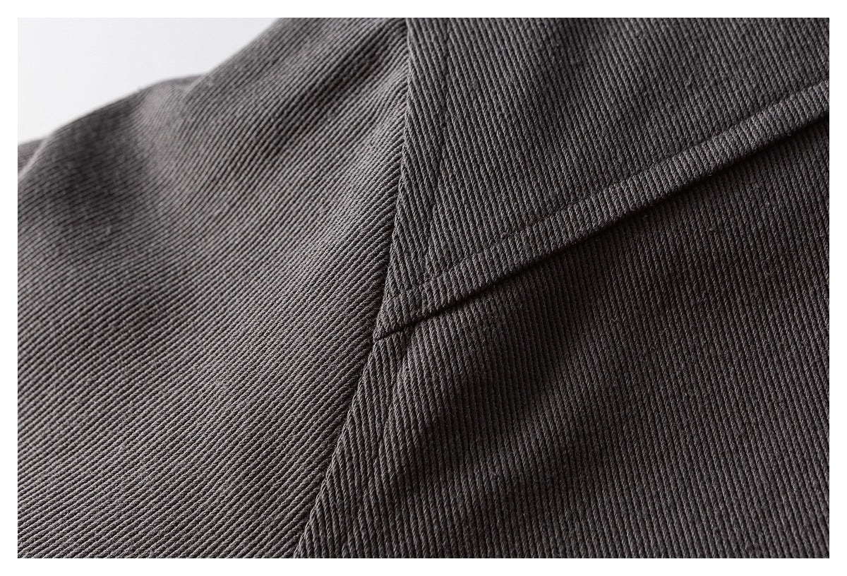 Close-up of charcoal jacket fabric showing a curved stitched seam.