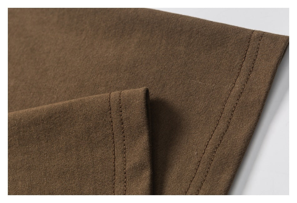Close-up of a brown garment showing a folded edge and double-stitched seam.