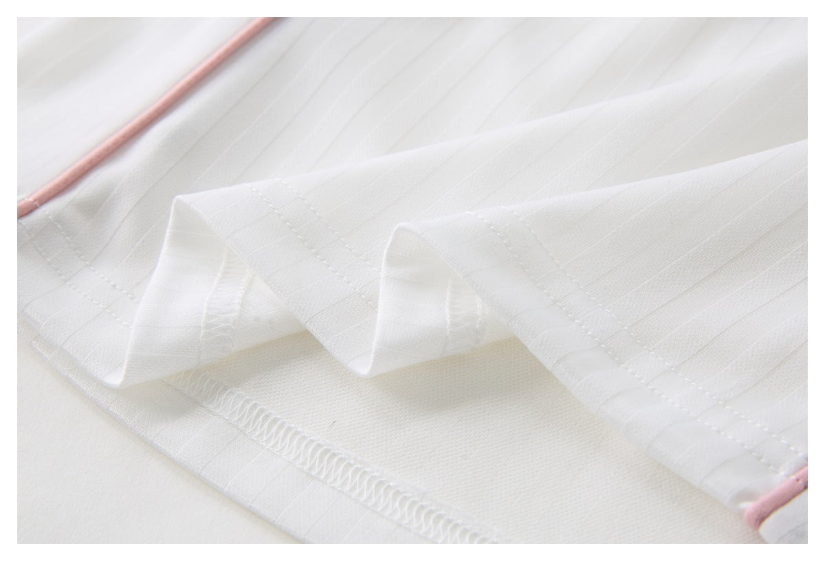 Close-up of the white pinstriped jersey's folded hem, stitching, and pink edge piping.