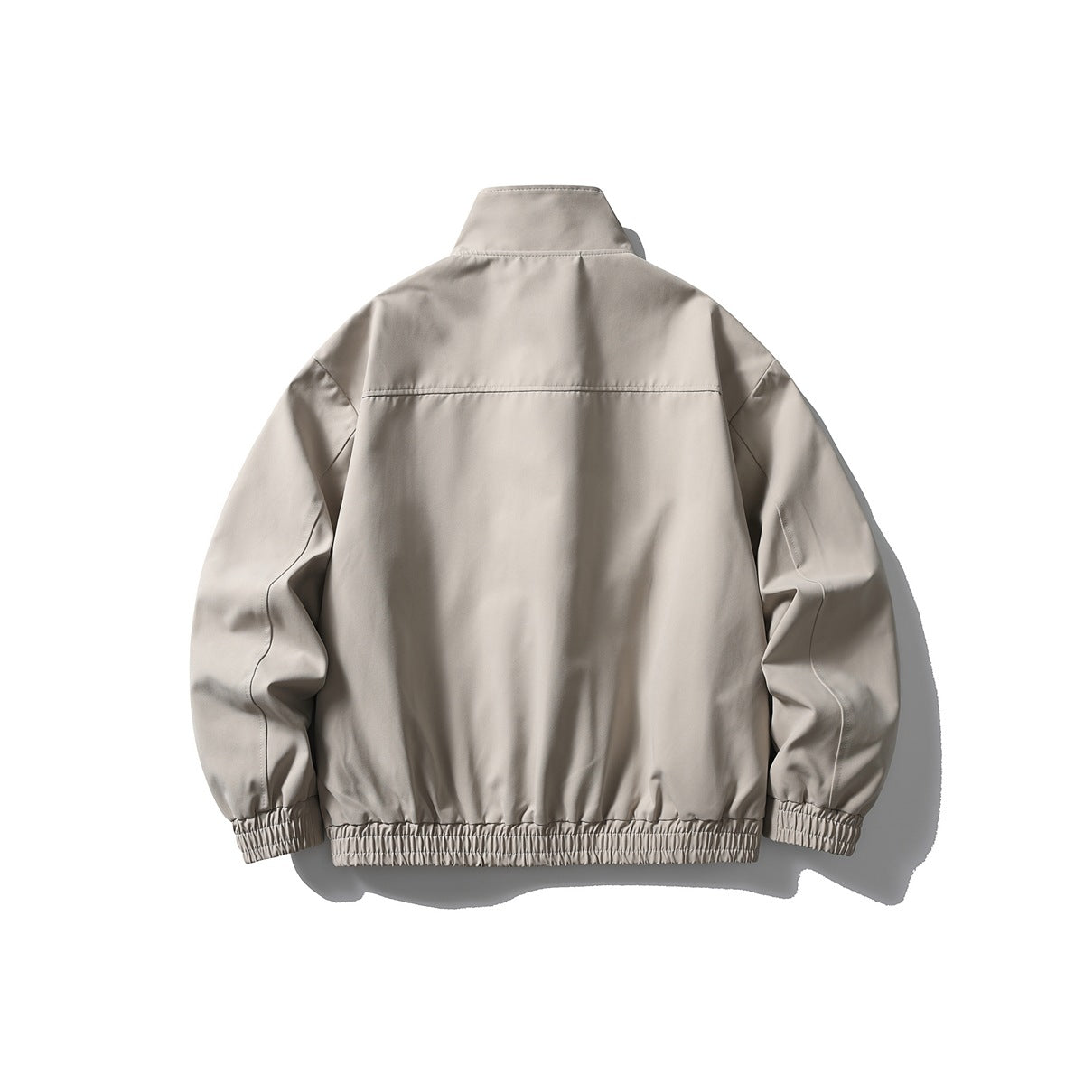Back view of a light taupe jacket with a high collar, long sleeves, and gathered elastic cuffs and hem.