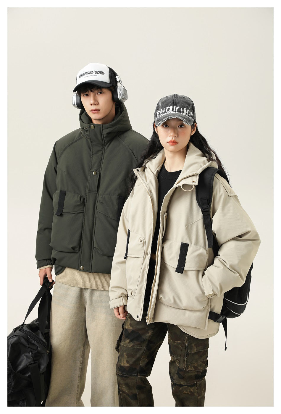 Two models wear dark olive and light beige hooded utility jackets with large flap pockets; the beige jacket is partly
