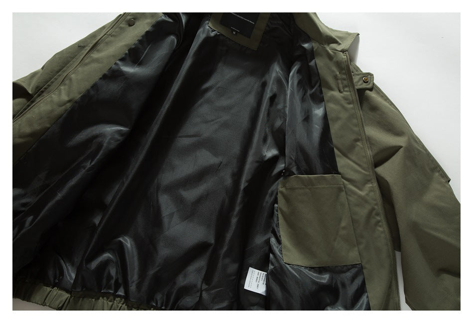 Olive jacket opened flat, showing its black lining, inner pocket, zipper and garment labels.