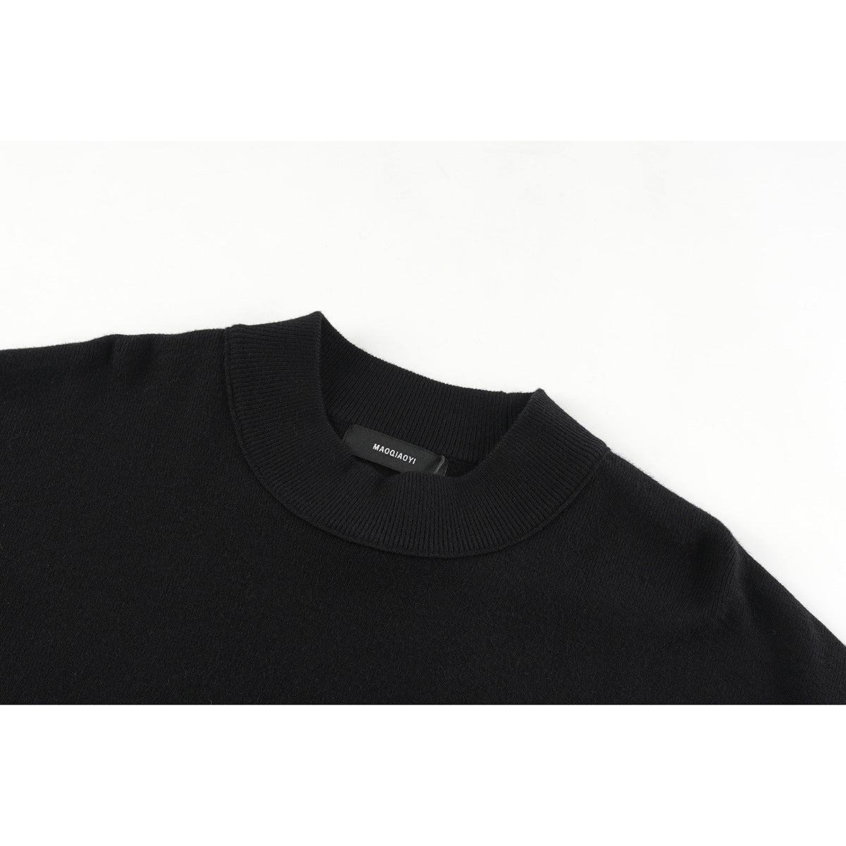 Close-up of a black knit sweater's ribbed crew neckline and small inner label.