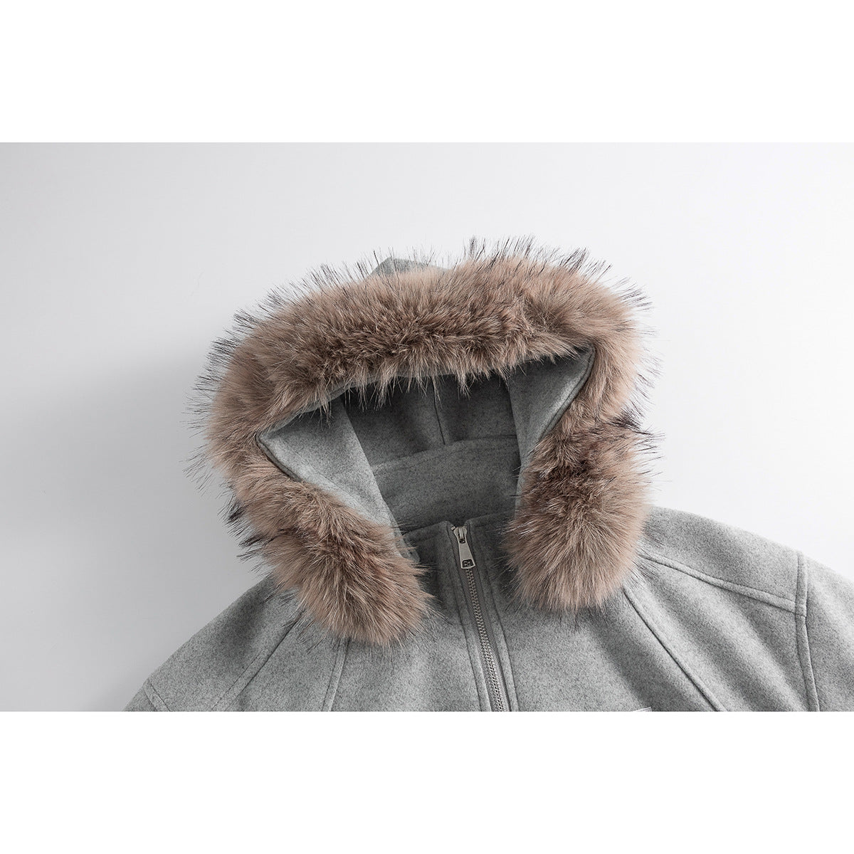 Close-up of a gray zip-up jacket's hood with thick brown fur trim and a glimpse of the front zipper.