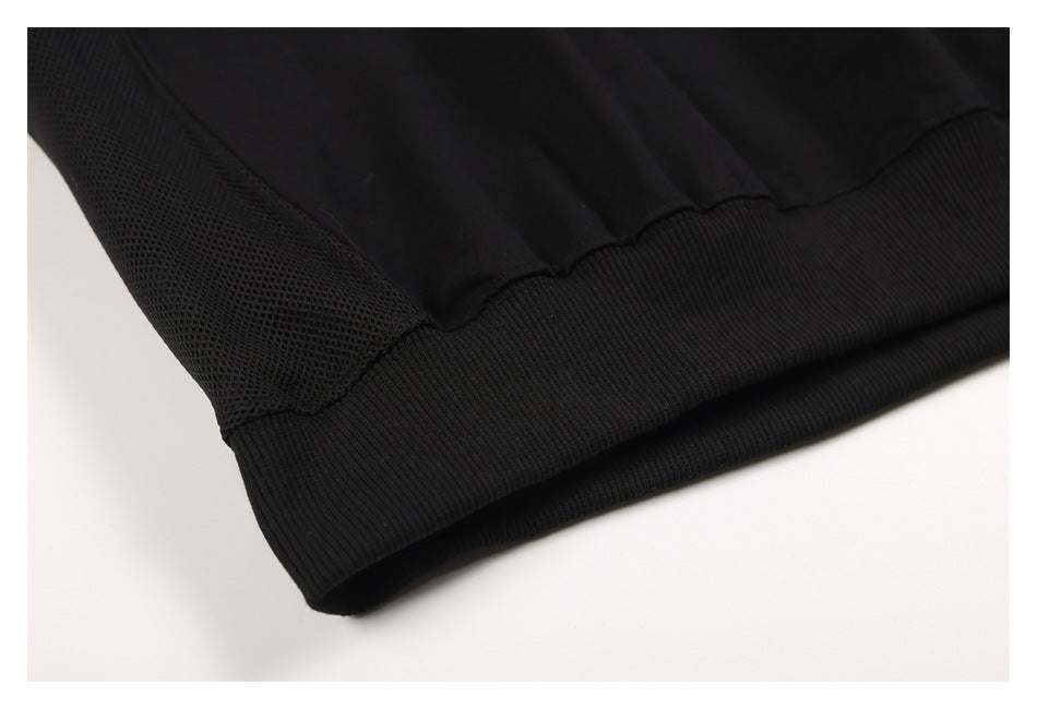 Close-up of the black sweatshirt's ribbed hem and textured mesh side panel.