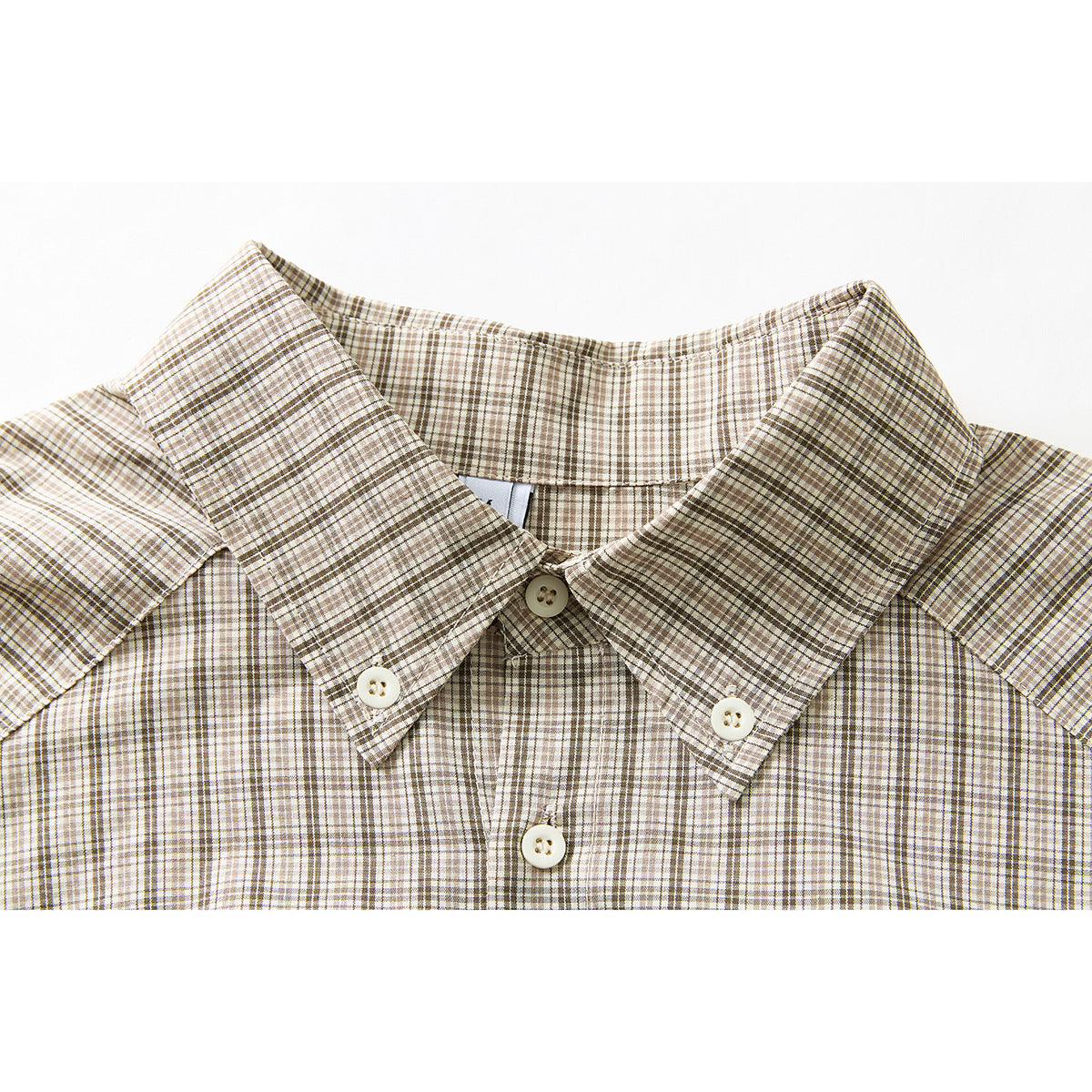 Close-up of a beige and brown plaid shirt collar with small buttons and part of the button placket.