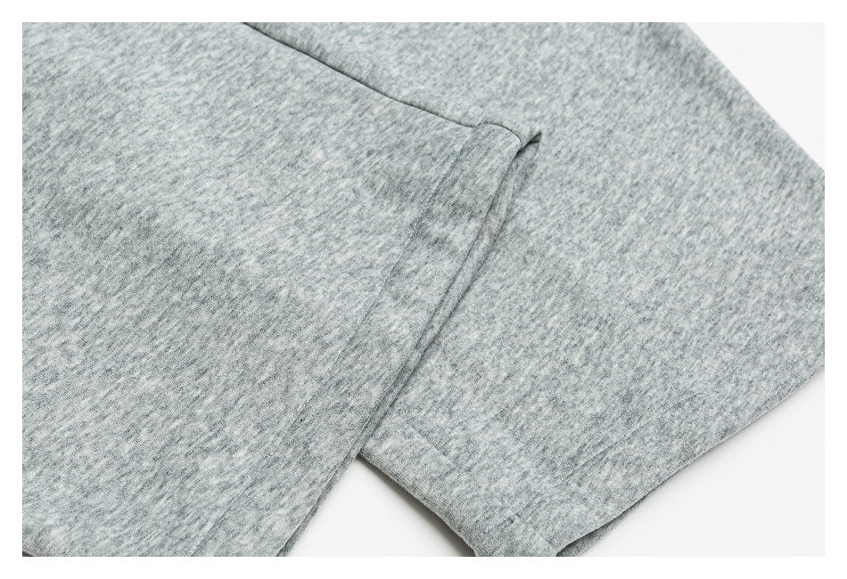 Close-up of heather gray pants showing a narrow pocket opening and stitching.