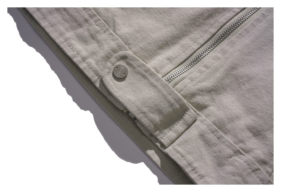 Close-up of a buttoned side tab beside the jacket’s zipper.