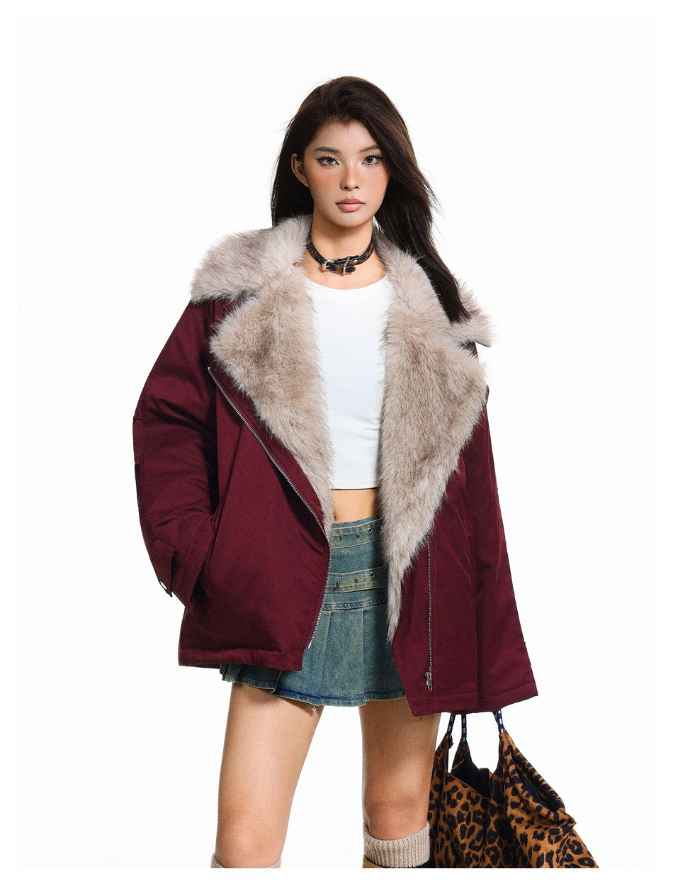 Model wearing an open burgundy jacket with a large light plush collar and an angled silver zipper.