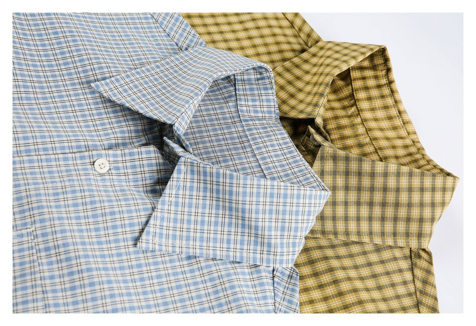 Close-up of overlapping blue and mustard-yellow plaid button-up shirts, showing collars, cuffs, and buttons.