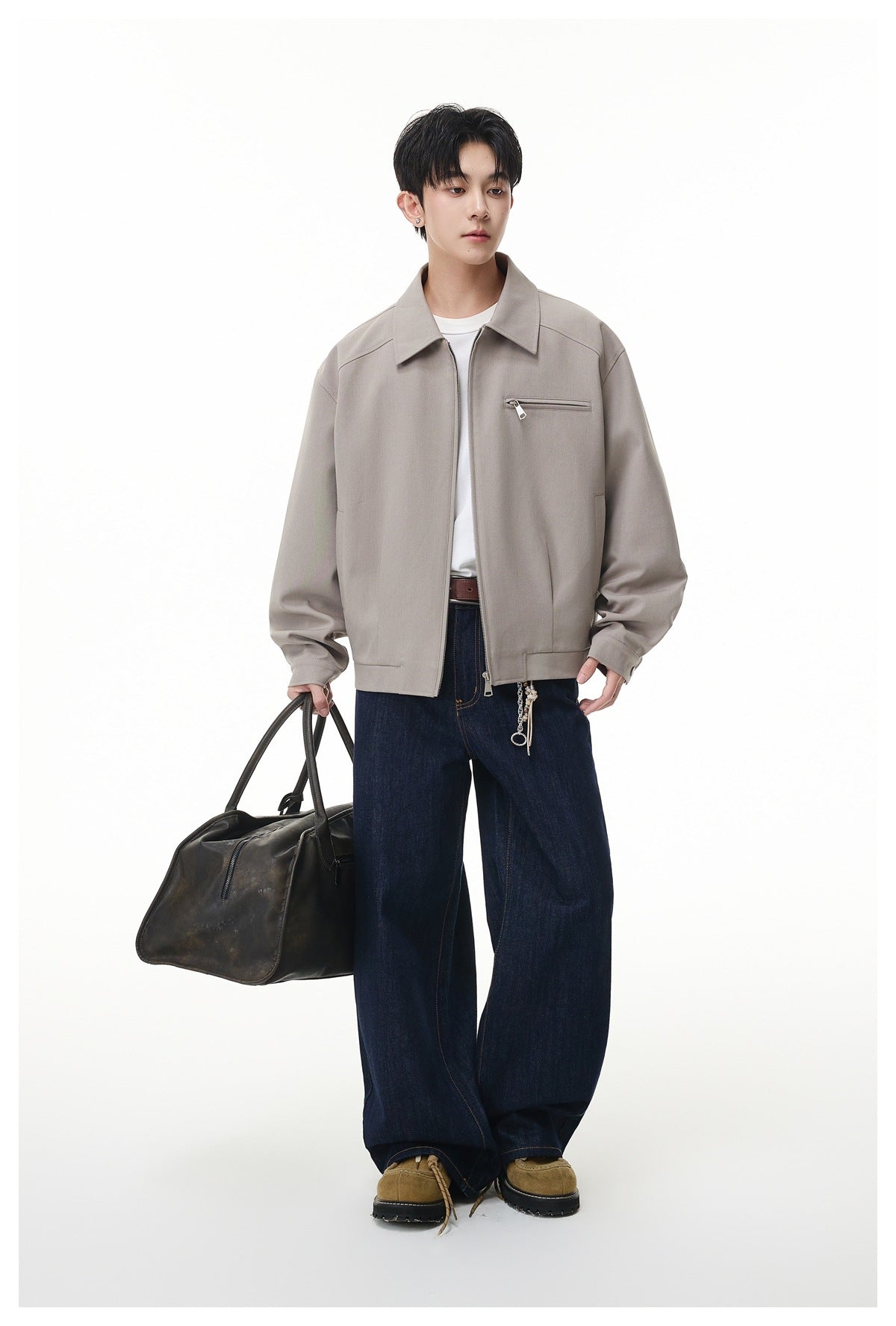 Full-length model wearing a light taupe zip-front jacket with a pointed collar and chest zipper pocket.