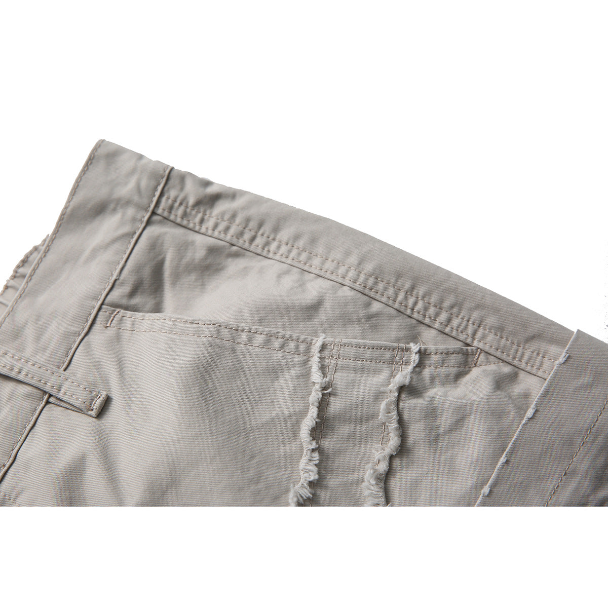 Close-up of light gray shorts showing the waistband, a back pocket, and frayed seam details.