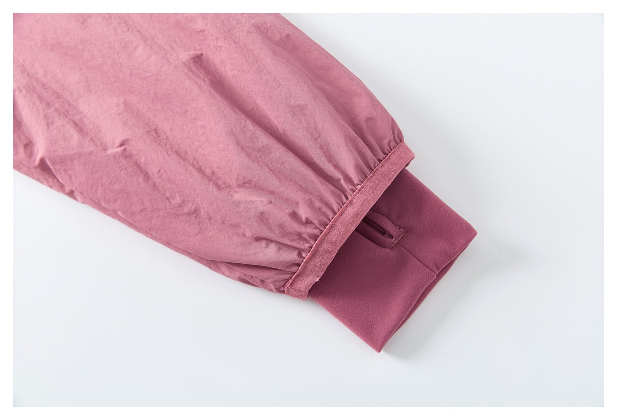 Close-up of a pink jacket sleeve ending in a wide darker mauve cuff.