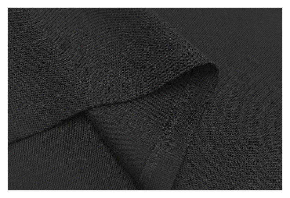 Close-up of a black polo sleeve hem showing the inside seam and stitching.