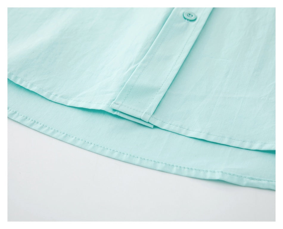 Close-up of the aqua shirt's curved hem, double stitching, and lower front placket.