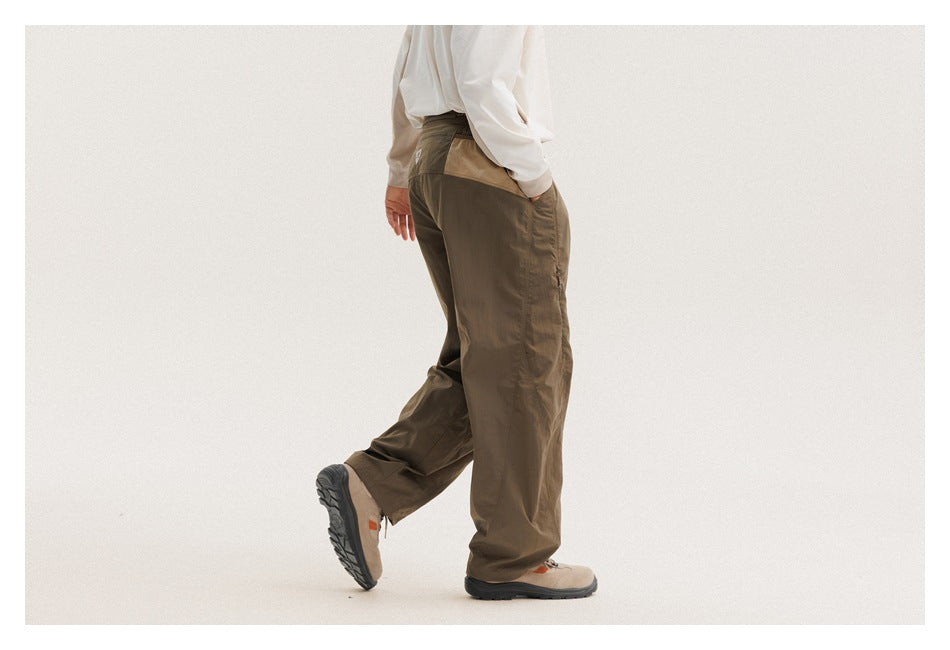 Three-quarter rear view of a model wearing loose olive-brown pants with gathered cuffs.