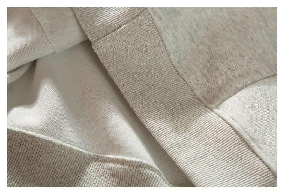 Close-up showing the inside seam and ribbed waistband of a light gray heathered sweatshirt.