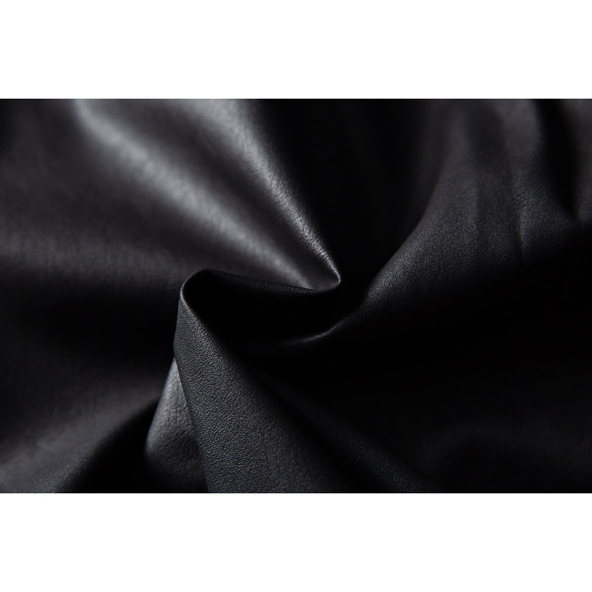 Close-up of the softly folded, subtly textured black jacket material.