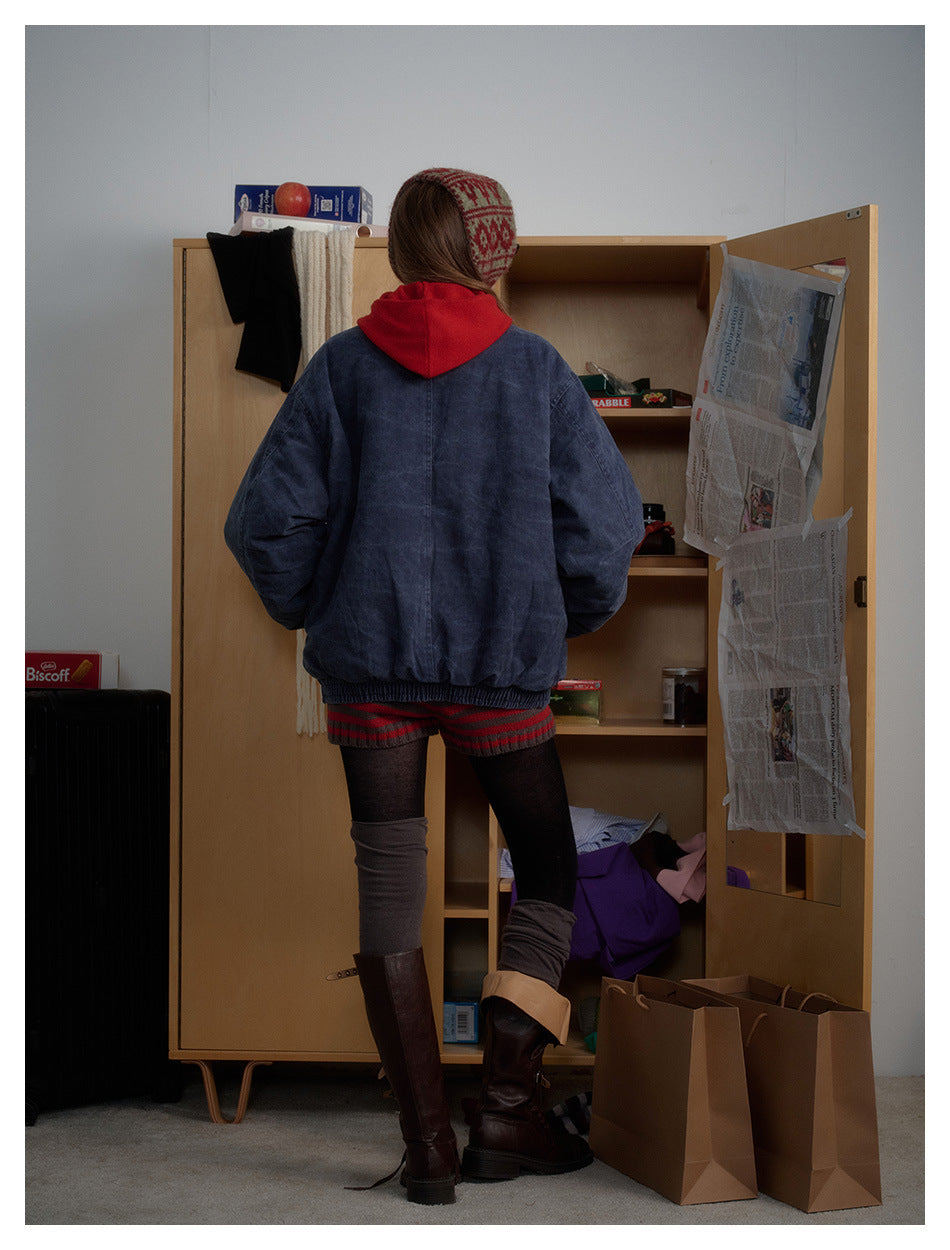 Back view of a model wearing an oversized dark indigo jacket with elastic cuffs and hem.