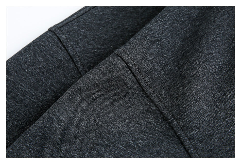 Close-up of intersecting seams on charcoal heather garment fabric.