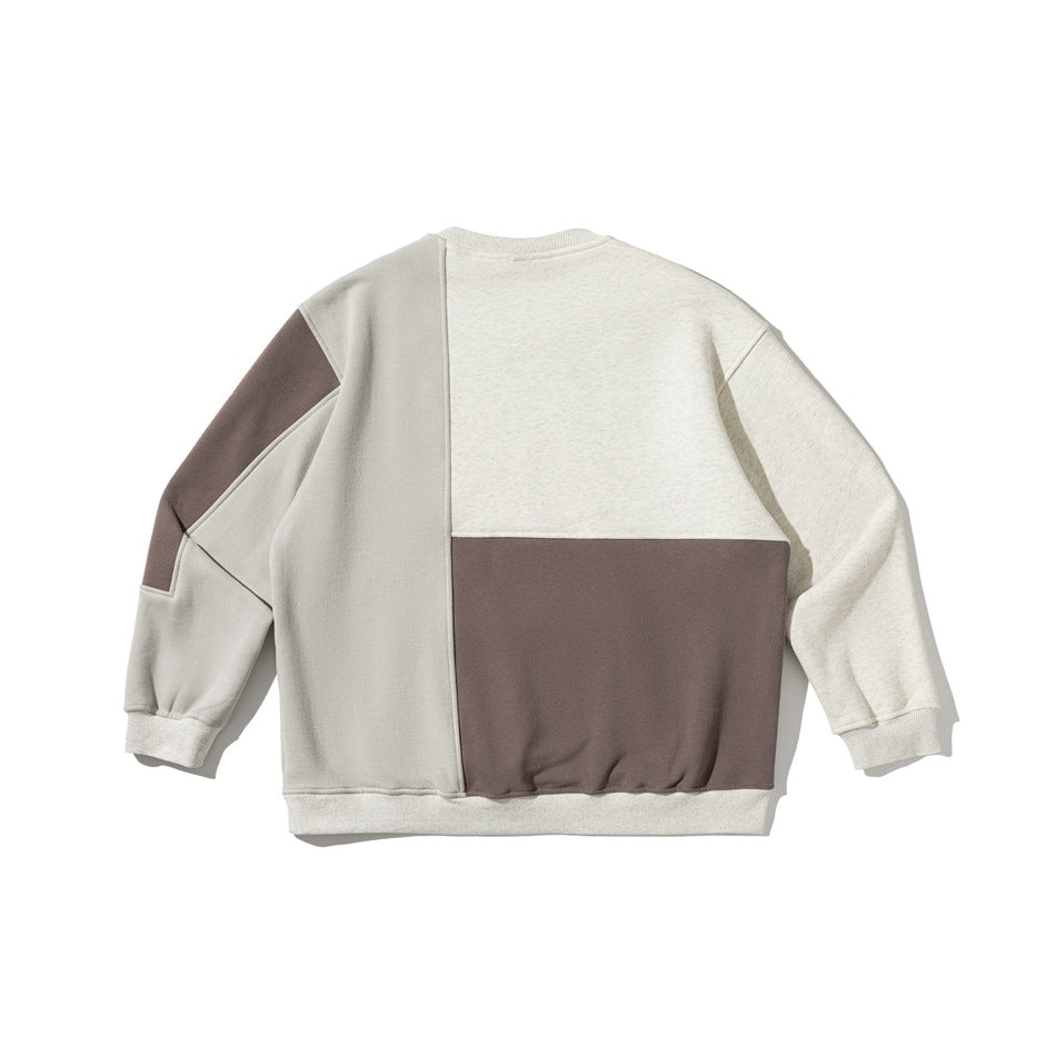 Flat lay of the sweatshirt back, with cream, pale gray, and taupe color-block panels and a ribbed hem.