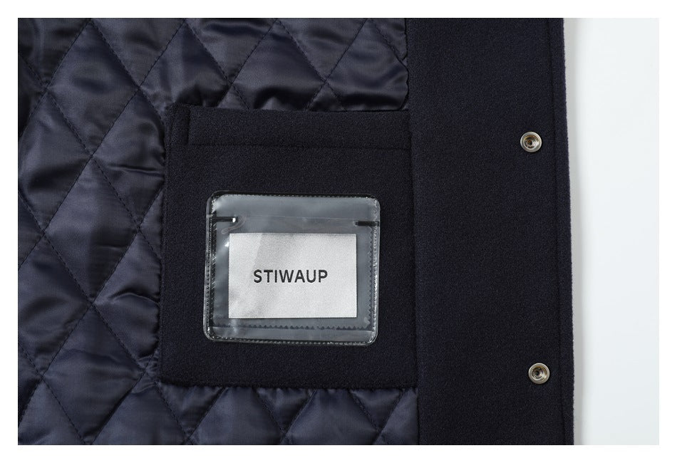 Inside view of navy quilted lining, a pocket with a clear label holder, and metal snap closures.