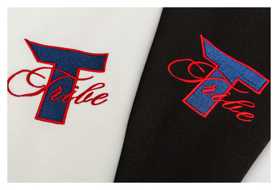 Close-up of matching red-and-blue embroidered script on ivory and black jacket fabric.