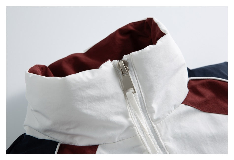 Close-up of a white jacket’s tall collar, burgundy lining and large front zipper, with navy and burgundy panels visible.