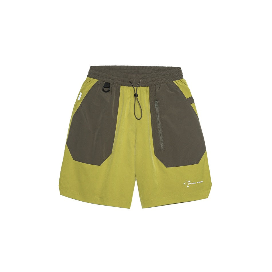 Ginger-yellow shorts with olive-brown panels, drawcord waist and zip pocket, front view on white background