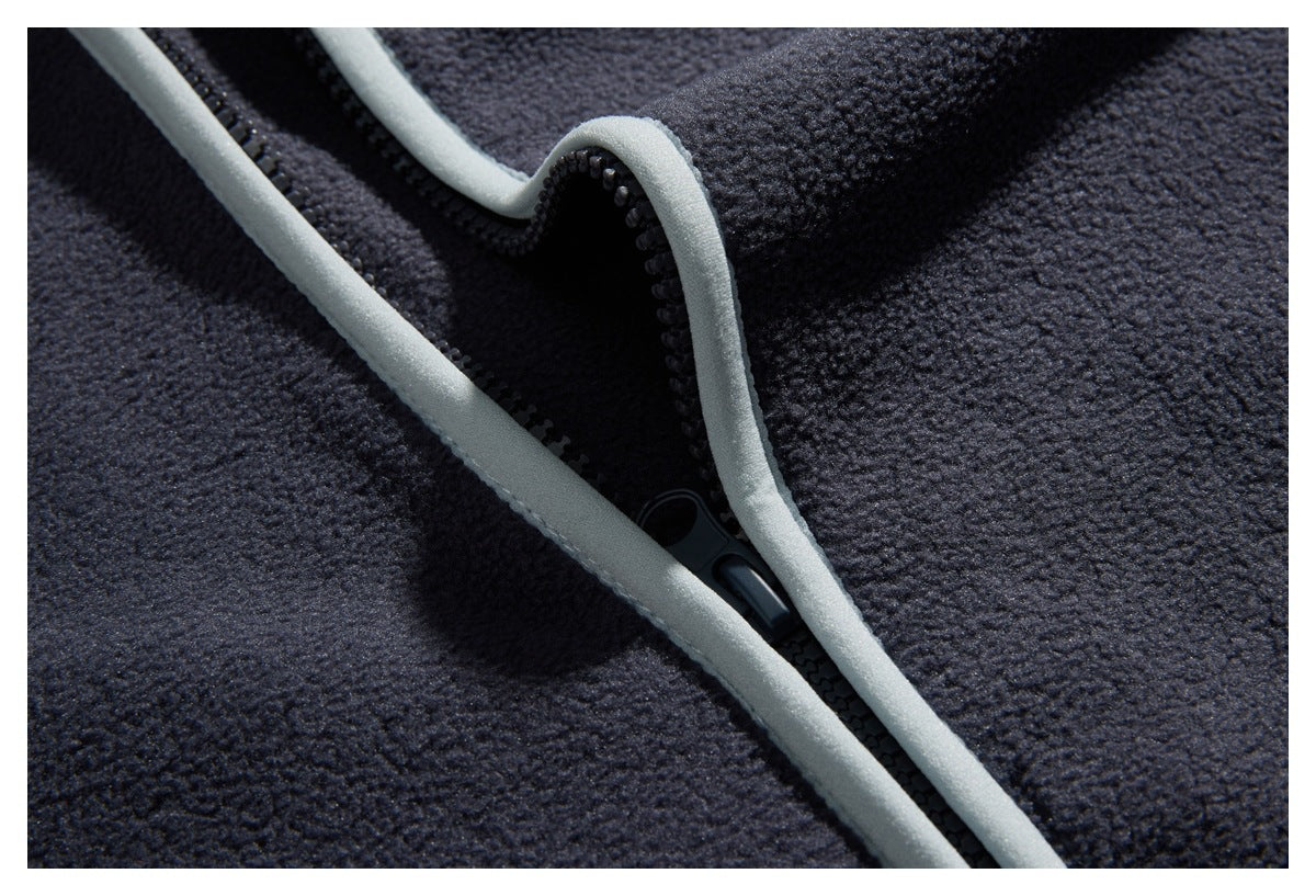 Close-up of a dark navy textured garment with a black zipper and light gray trim.