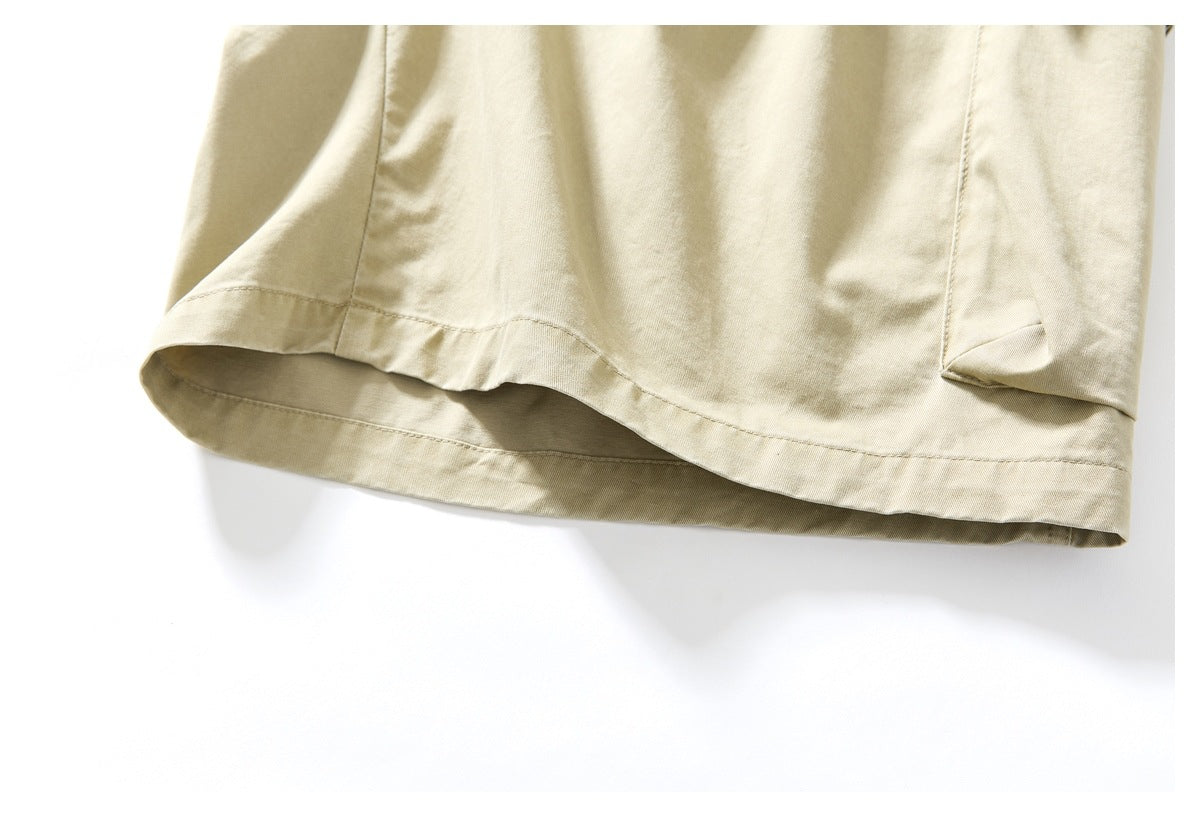 Close-up of the stitched hem on beige trousers.