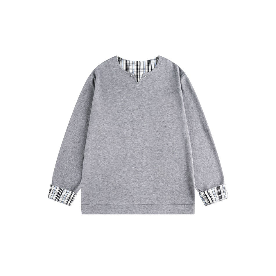Gray long-sleeve top with V-notch neckline, studs, and plaid inner collar and cuffs, flat front view