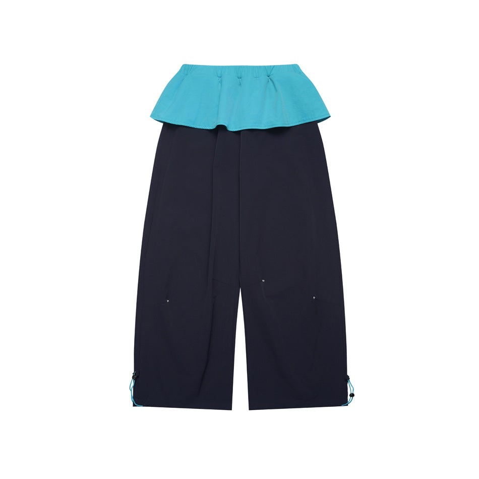 Navy wide-leg pants with a turquoise flounce waist panel and hem drawcords, flat lay