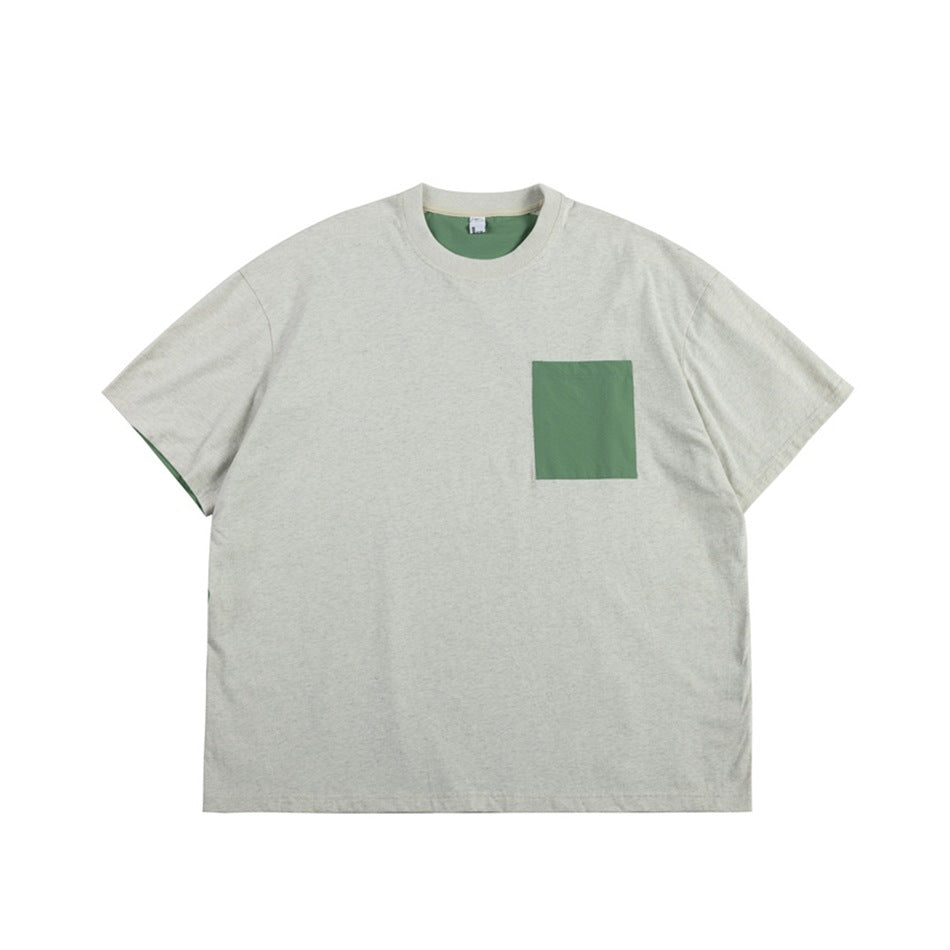 Heathered light gray short-sleeve T-shirt with a green square chest pocket and green inner neck, flat lay